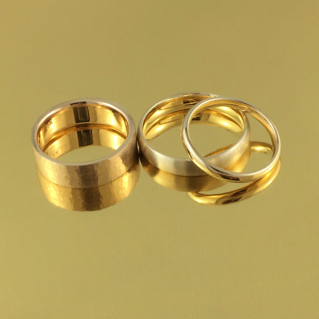 three recycled gold wedding rings in yellow gold